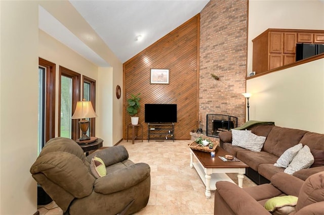 2501 Olde Creek Ct S, Leavenworth, KS 66048 - living area featuring high vaulted ceiling, wooden walls, an accent wall, and a brick fireplace