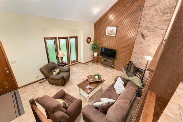 2501 Olde Creek Ct S, Leavenworth, KS 66048 - living area featuring an accent wall, wooden walls, high vaulted ceiling, and a fireplace