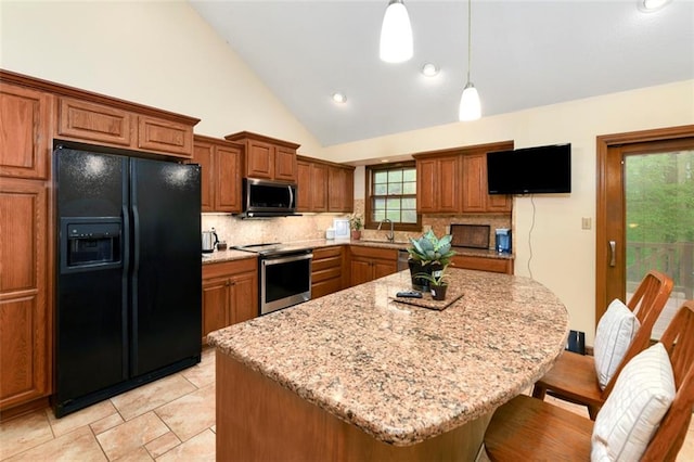 2501 Olde Creek Ct S, Leavenworth, KS 66048 - kitchen with stainless steel appliances, brown cabinetry, tasteful backsplash, vaulted ceiling, and recessed lighting