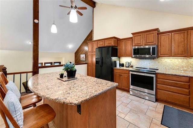 2501 Olde Creek Ct S, Leavenworth, KS 66048 - kitchen featuring appliances with stainless steel finishes, brown cabinets, ceiling fan, tasteful backsplash, and a kitchen bar