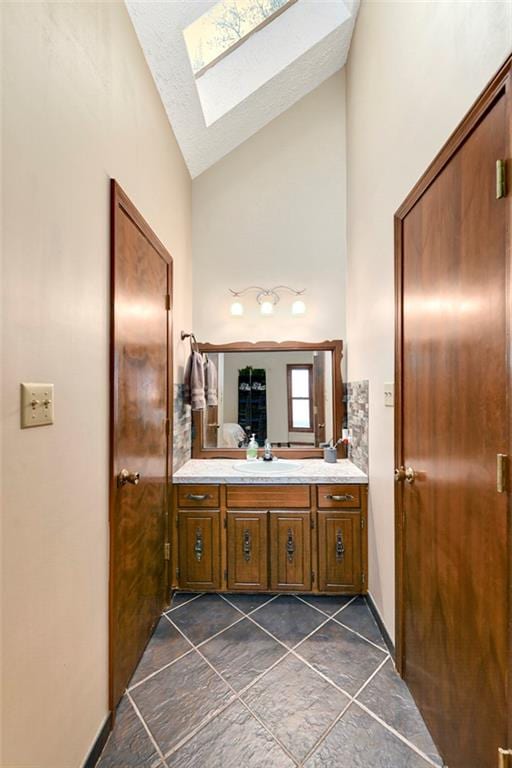 2501 Olde Creek Ct S, Leavenworth, KS 66048 - bathroom with a skylight, vanity, high vaulted ceiling, and tile patterned flooring