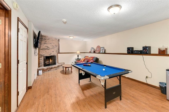 2501 Olde Creek Ct S, Leavenworth, KS 66048 - playroom featuring light wood-style floors, a textured ceiling, a brick fireplace, and billiards