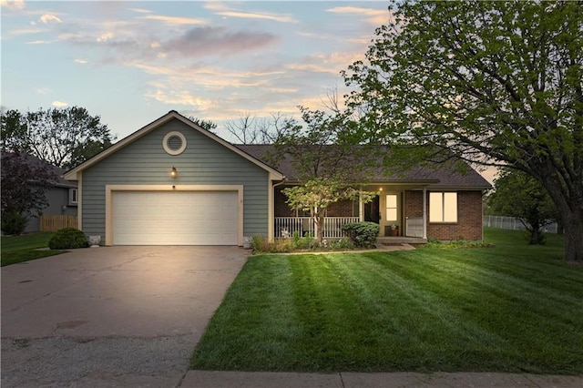 ranch-style home featuring covered porch, a front yard, brick siding, an attached garage, and driveway