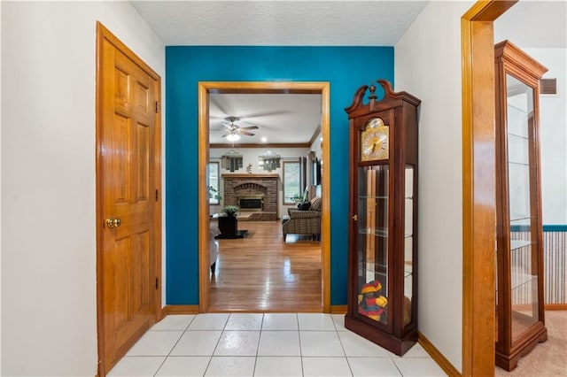 hallway with visible vents, baseboards, and light tile patterned floors