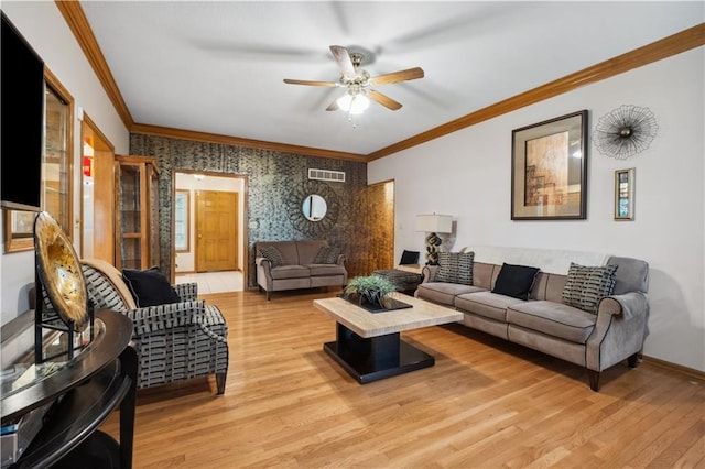 living area with a ceiling fan, visible vents, crown molding, baseboards, and light wood finished floors