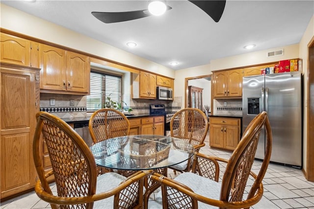 kitchen featuring visible vents, a ceiling fan, backsplash, and stainless steel appliances