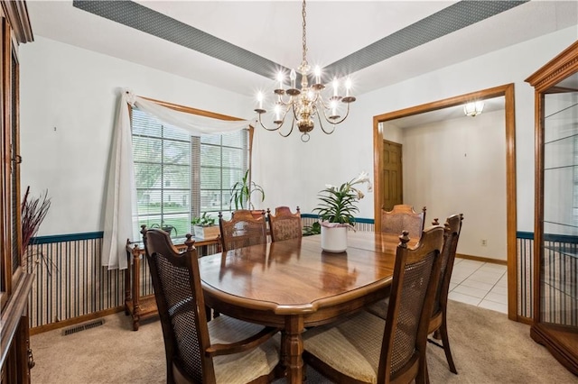 dining area with light carpet, a chandelier, baseboards, light tile patterned floors, and visible vents