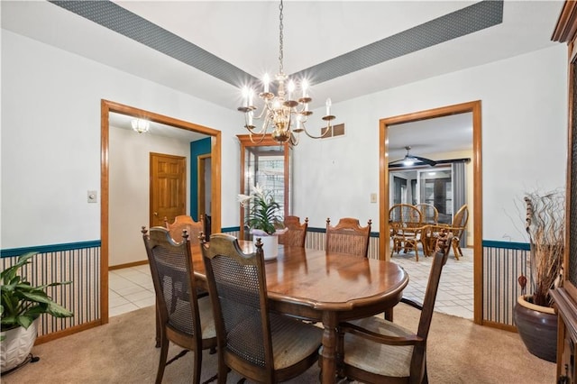 dining space featuring visible vents, light tile patterned floors, baseboards, ceiling fan with notable chandelier, and light carpet