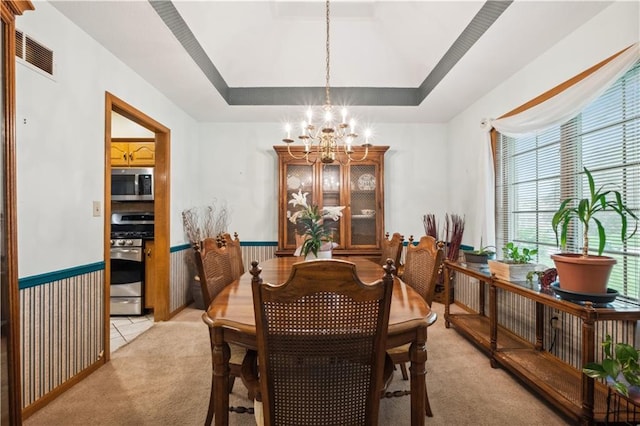 dining space with visible vents, plenty of natural light, a notable chandelier, and light carpet