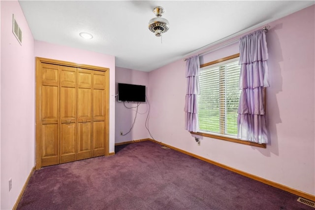 unfurnished bedroom featuring carpet flooring, baseboards, visible vents, and a closet