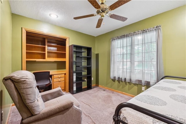 bedroom with carpet flooring, a ceiling fan, baseboards, and a textured ceiling