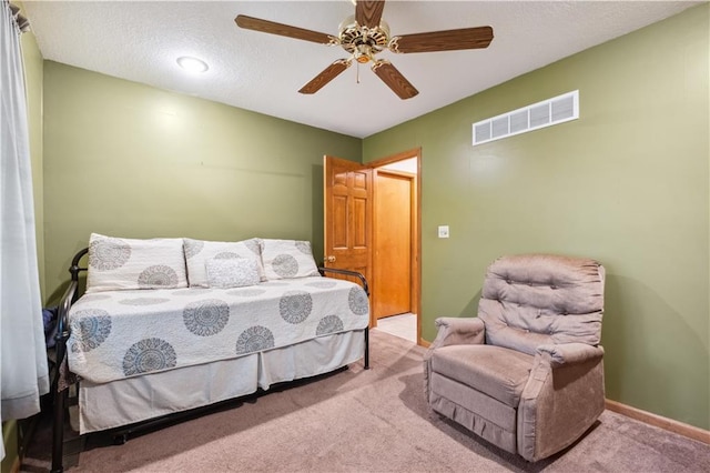bedroom featuring carpet flooring, a textured ceiling, a ceiling fan, baseboards, and visible vents