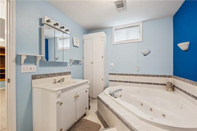 bathroom featuring a whirlpool tub, a textured ceiling, visible vents, and a healthy amount of sunlight