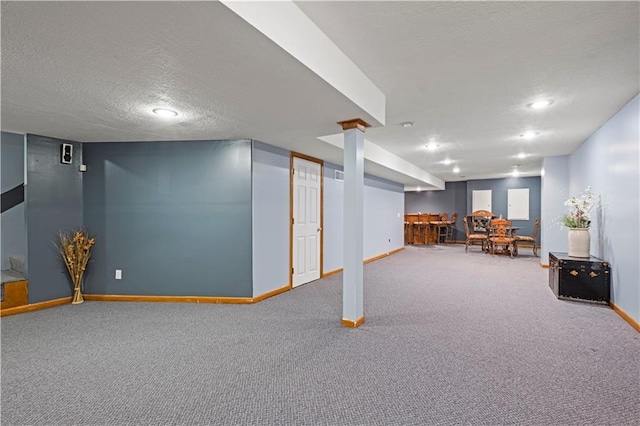finished below grade area with carpet flooring, a textured ceiling, baseboards, and recessed lighting