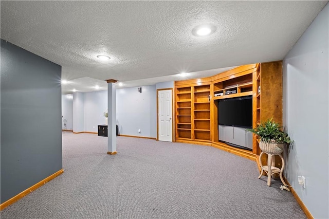 finished below grade area with baseboards, a textured ceiling, and carpet floors