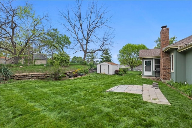 view of yard featuring a patio, a shed, and an outbuilding