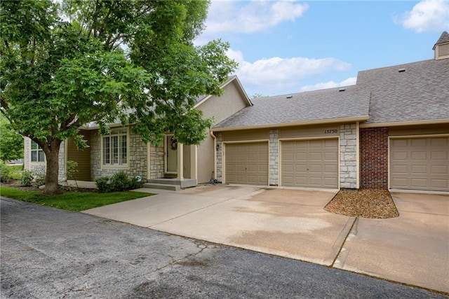 15730 S Brentwood St Unit 2600, Olathe, KS 66062 - view of front facade with stone siding, driveway, a garage, a shingled roof, and stucco siding