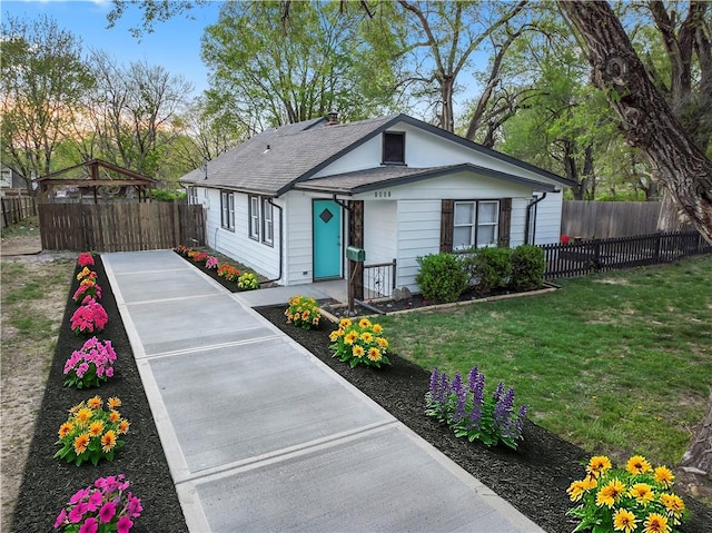 bungalow-style home with a gazebo, concrete driveway, fence, a front yard, and roof with shingles