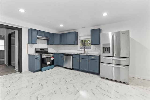 kitchen with under cabinet range hood, light countertops, a sink, baseboards, and appliances with stainless steel finishes