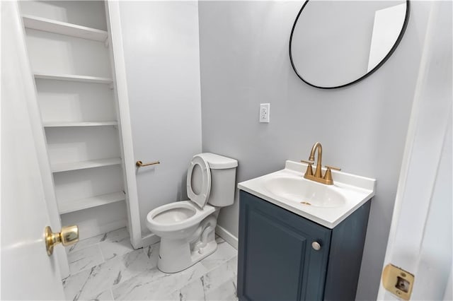 bathroom featuring baseboards, marble finish floor, vanity, and toilet