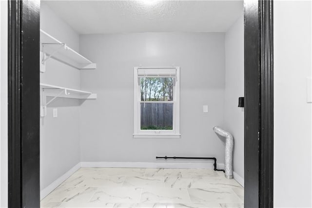 walk in closet with marble finish floor