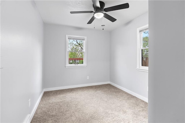spare room with baseboards, carpet, and a healthy amount of sunlight
