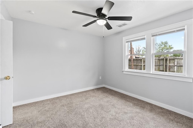 unfurnished room with carpet, visible vents, a ceiling fan, and baseboards