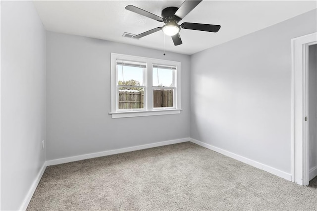 unfurnished room with baseboards, a ceiling fan, visible vents, and carpet