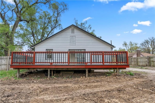 rear view of property featuring fence and a deck