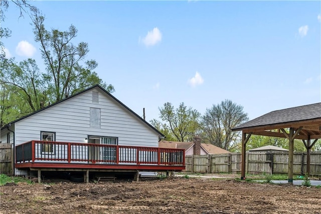 back of house featuring a wooden deck and fence