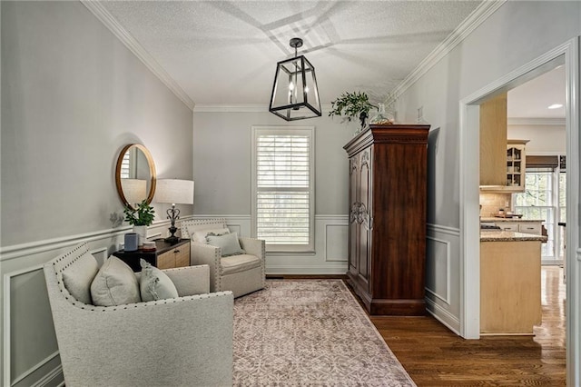 living area with ornamental molding, dark wood-style flooring, and a wealth of natural light