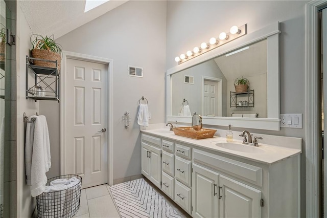 full bath with visible vents, a sink, and vaulted ceiling with skylight