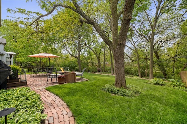 view of yard with fence, a fire pit, and a patio area