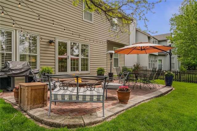 back of house featuring fence, a lawn, and a patio area