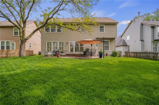 back of house with a lawn, fence private yard, and a patio area