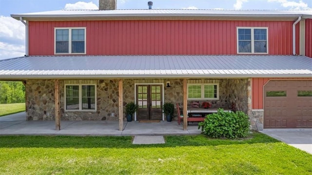 farmhouse inspired home featuring stone siding, french doors, a front lawn, and a chimney