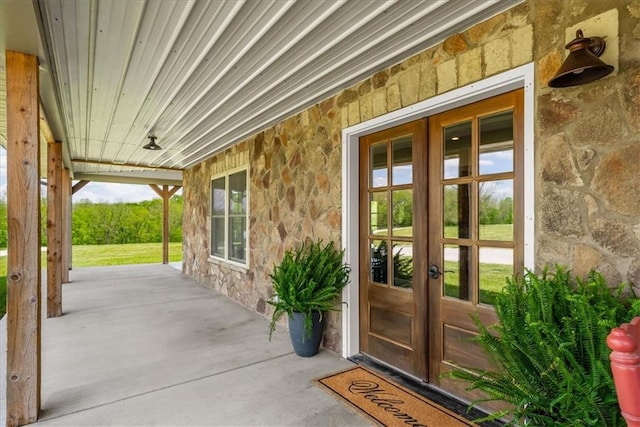 doorway to property featuring stone siding and french doors