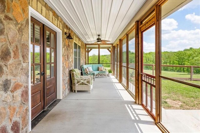 sunroom featuring french doors, ceiling fan, and an outdoor living space