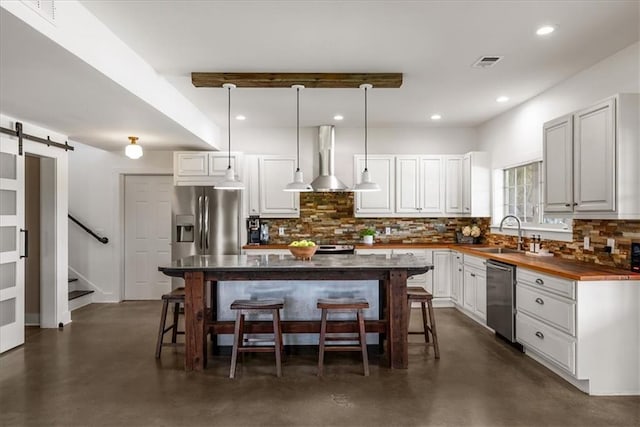 kitchen with appliances with stainless steel finishes, finished concrete flooring, a sink, a kitchen bar, and backsplash