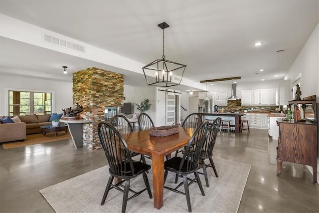 dining room featuring concrete floors, a chandelier, and recessed lighting