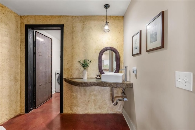 hallway with washer / dryer and finished concrete flooring