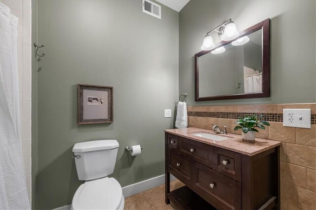 full bathroom featuring toilet, vanity, tile patterned floors, baseboards, and curtained shower