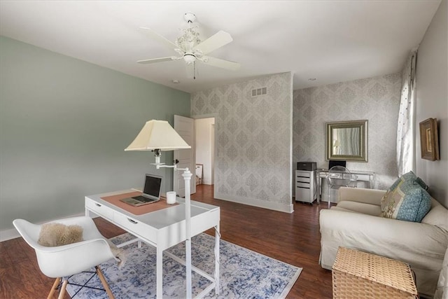 office featuring wallpapered walls, baseboards, dark wood-type flooring, and a ceiling fan