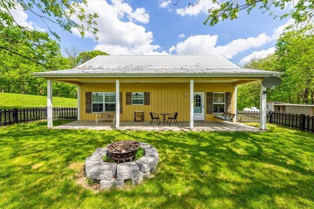back of property with an outdoor fire pit, a patio area, and metal roof