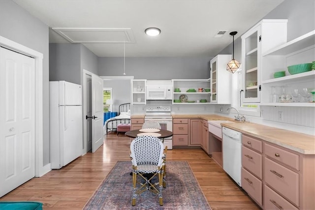 kitchen with open shelves, white appliances, a sink, pendant lighting, and light wood finished floors