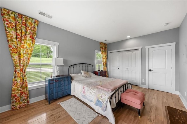 bedroom with baseboards, hardwood / wood-style flooring, recessed lighting, and a closet