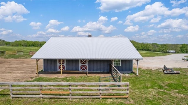 view of front facade with an exterior structure, an outdoor structure, metal roof, and a view of countryside