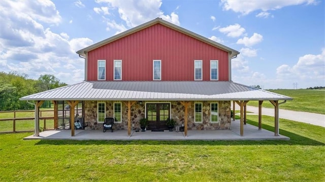 rear view of property with stone siding and a patio