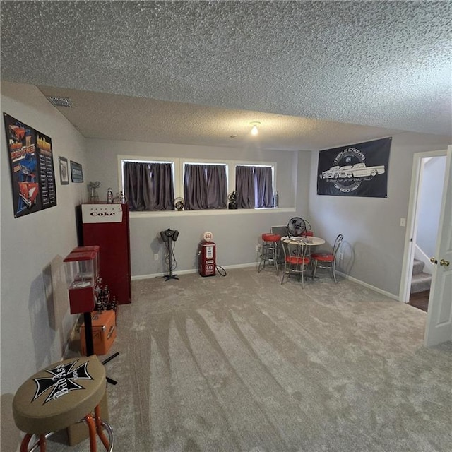 rec room featuring a textured ceiling, visible vents, baseboards, and carpet floors