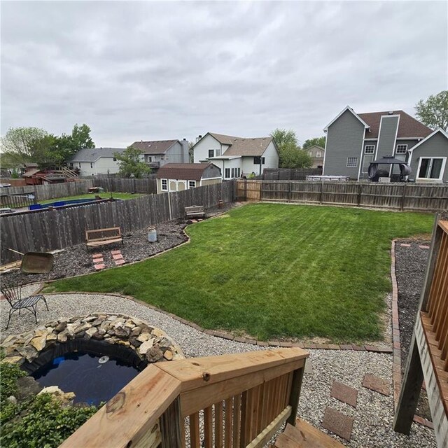 view of yard featuring a fenced backyard and a residential view